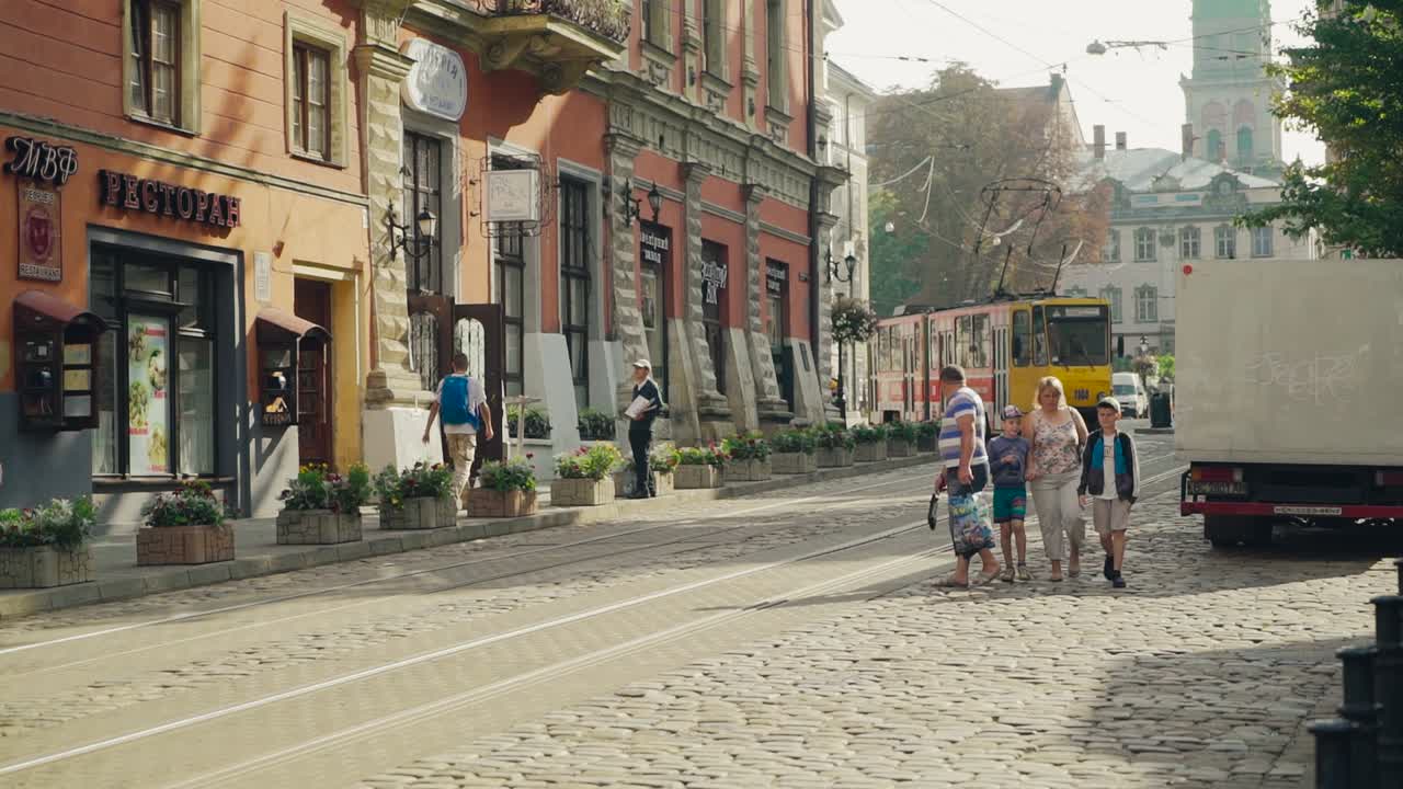 Ancient part of the city Lviv in Ukraine with old buildings, tram and people in the street. Narrow street of historical centre of Europe with tourists and old transport.