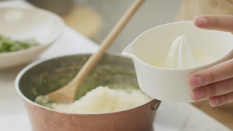 woman preparing sauce for pasta at table