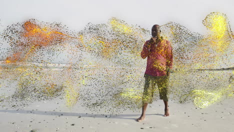 senior man standing barefoot on shore as swirling yellow-orange particles showcasing tech concept
