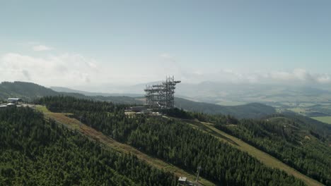90-degrees-orbit-aerial-shot-of-a-sky-walk-tower-attraction-in-Dolni-Morava,-Czech-Republic-and-a-nearby-MTB-bicycle-trail