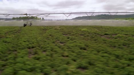 Modern-Irrigation-System-Watering-Farm-Land---aerial-sideways