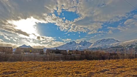 Railroad-cargo-train-passing-by-snow-covered-mountains