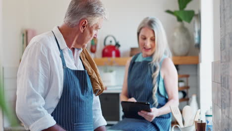 una pareja de mayores cocinando juntos en la cocina.
