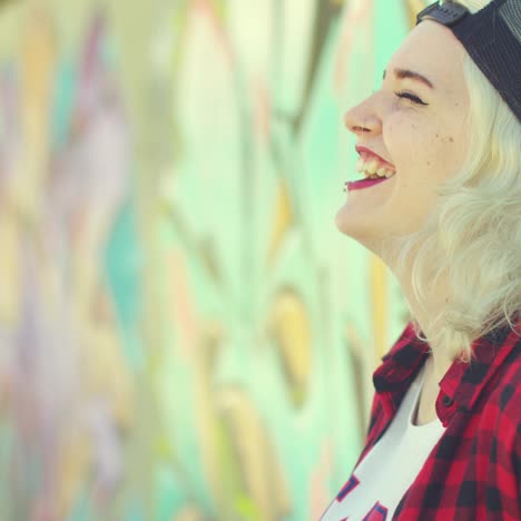 Two-hipster-friends-chatting-in-front-of-graffiti