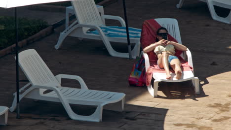 beautiful young women relaxing on the deck chair near the pool