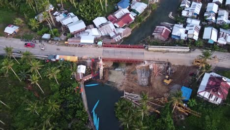 Construction-work-at-Maasin-river-bridge-by-the-bent-palm-tree-swing-on-Siargao-Island,-Philippines-after-typhoon