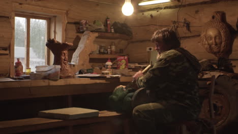 woodcarver at work in a rustic cabin