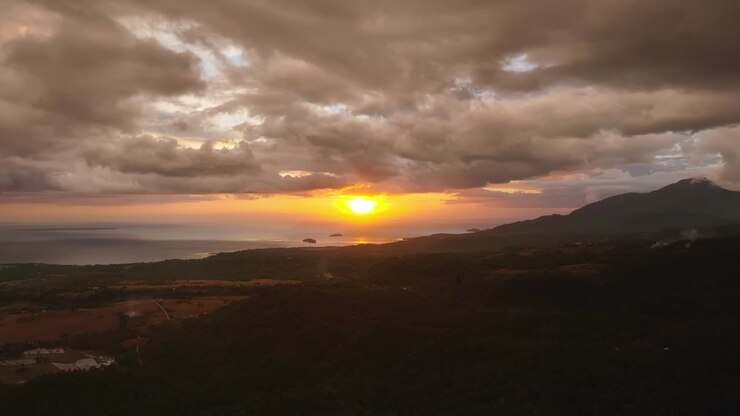Paesaggio montano pittoresco con tramonto dorato sull'oceano