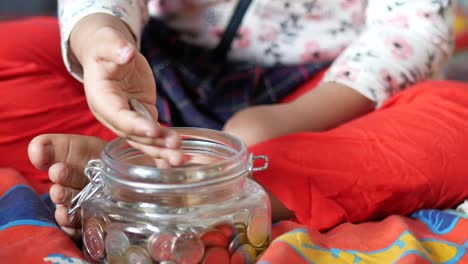 child girl pile coin for saving. sitting on floor