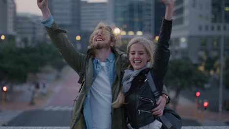 retrato de una pareja joven feliz con los brazos levantados celebrando un estilo de vida de viaje exitoso sonriendo alegremente disfrutando de las vacaciones juntos abrazándose en la ciudad al atardecer en cámara lenta