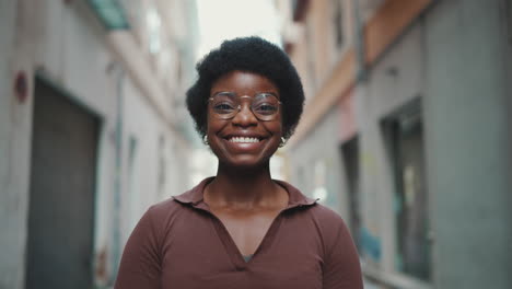 cheerful african woman in glasses looking happy outdoors