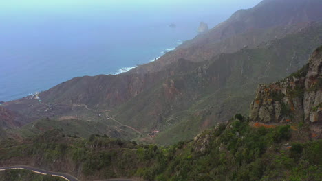 Asphalt-roads-winding-through-the-high-sharp-cliffs-and-peaks-of-the-mountains-on-the-Canaria-island-with-villages-in-the-valleys-and-the-Atlantic-ocean-below