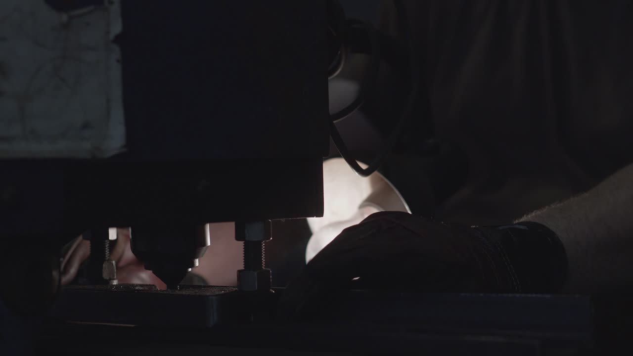 Close-up of worker using the iron punching machine.