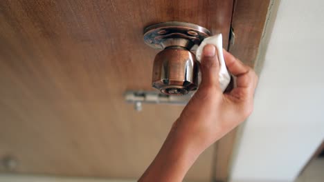 cleaning a door handle with a tissue