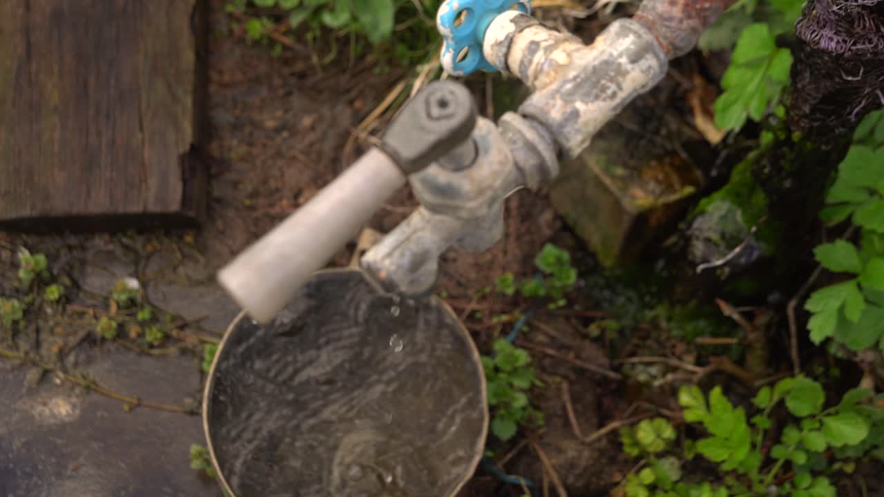L'acqua dal rubinetto gocciola nella vecchia casseruola 01