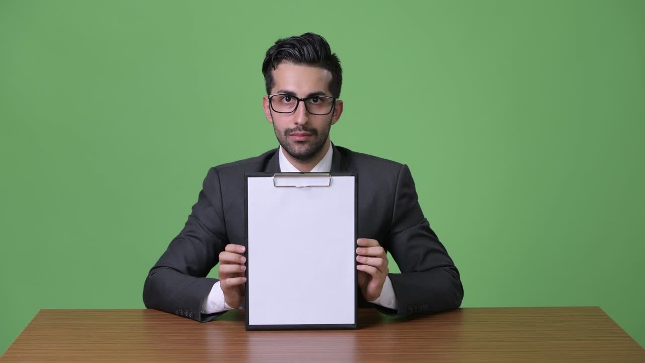 초록색 배경에 젊은 잘생긴 수염을 가진 페르시아 사업가