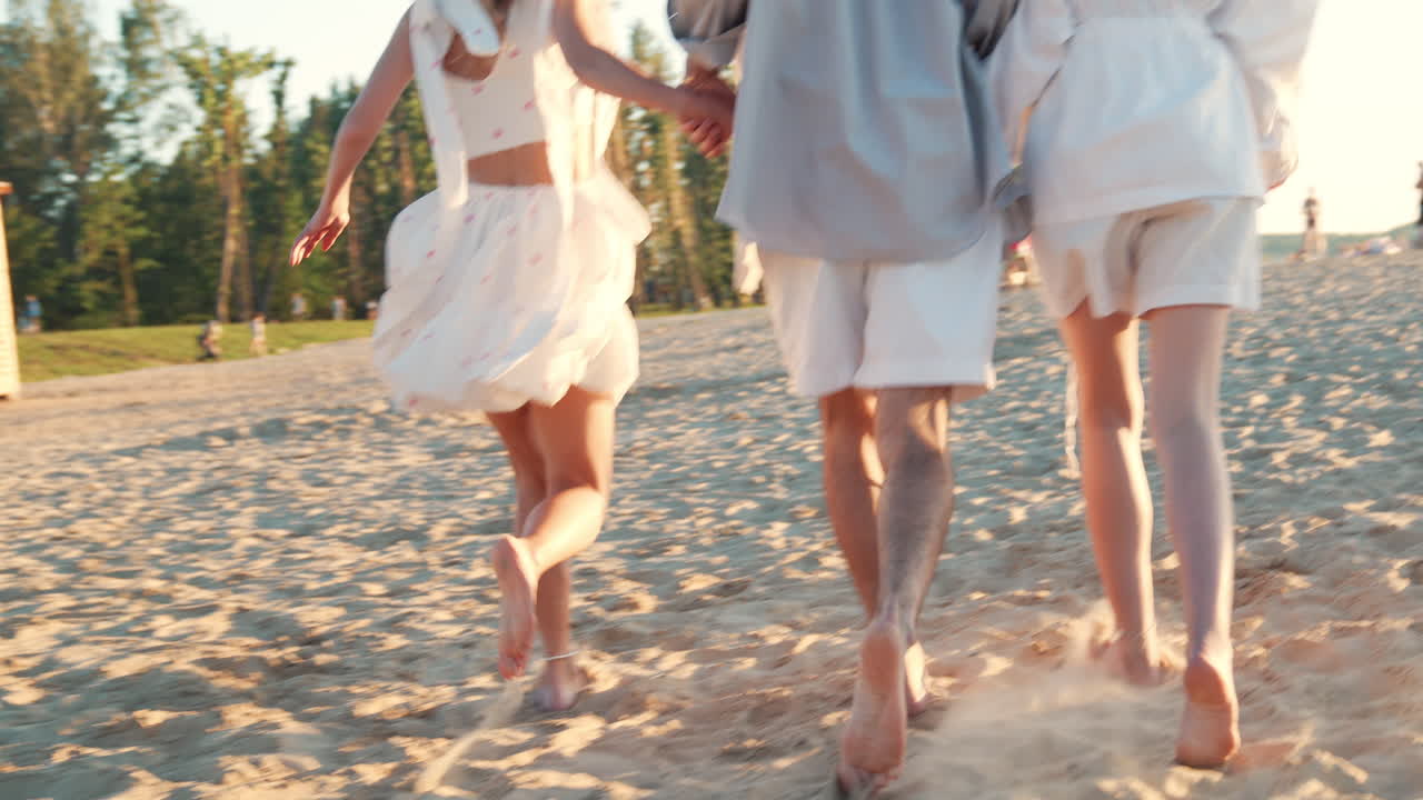 친구들이 해변에서 맨발로 달리고 있습니다.