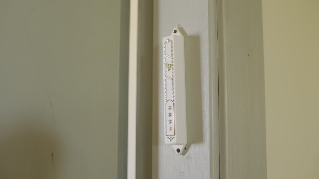 mano en una mezuzá - tradición judía al entrar o salir de la habitación