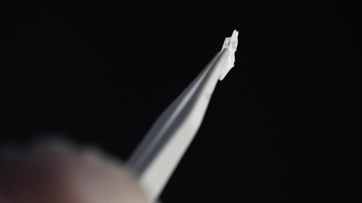 White Material Sample in Tweezers