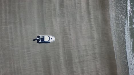 Aerial-bird-view,-amphibious-boat-travelling-on-the-beach-into-the-sea