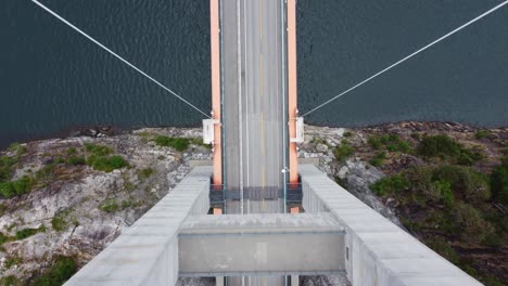 hardanger bridge - spectacular top down view from in between tower columns to road with hardangerfjorden sea below - birdseye aerial from different perspective - norway