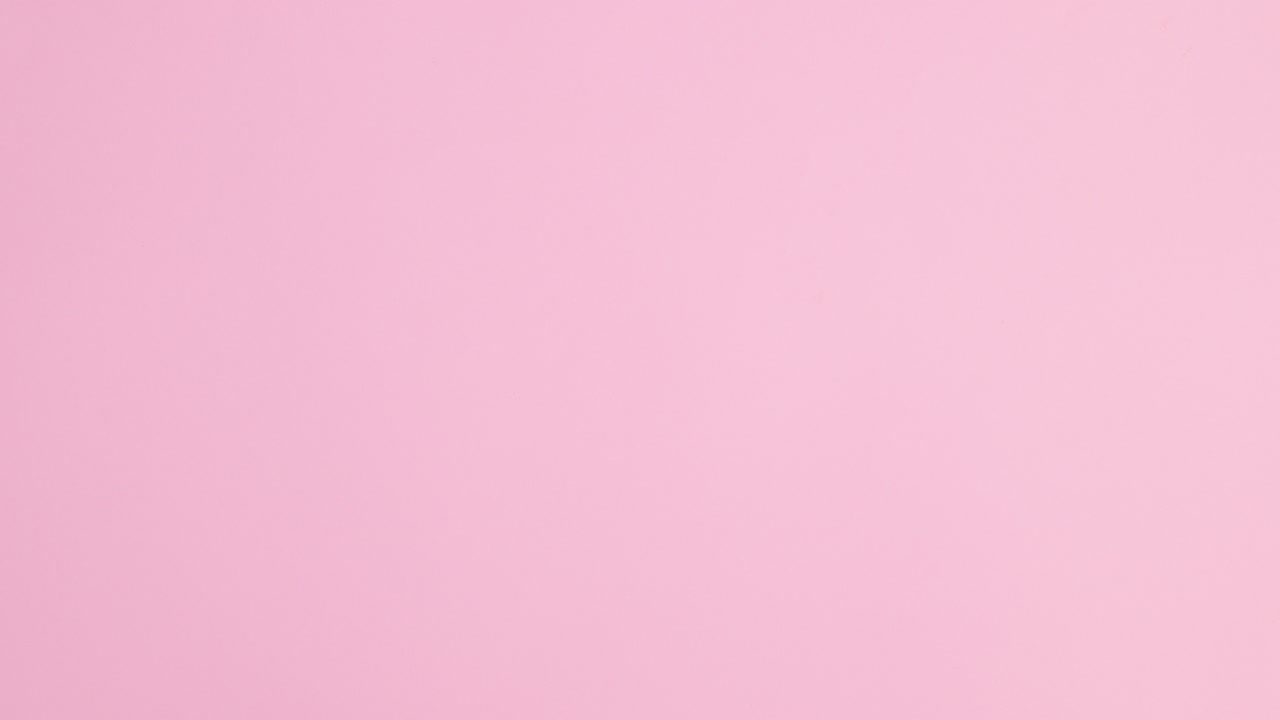 Summer beach accessories and straw bag and hat appear on pastel pink background. Stop motion