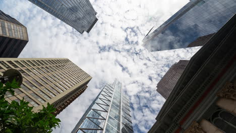 Look-up-time-lapse-of-Center-City-Philadelphia-featuring-the-Comcast-Towers-and-other-buildings-with-blue-skies,-sun,-and-clouds