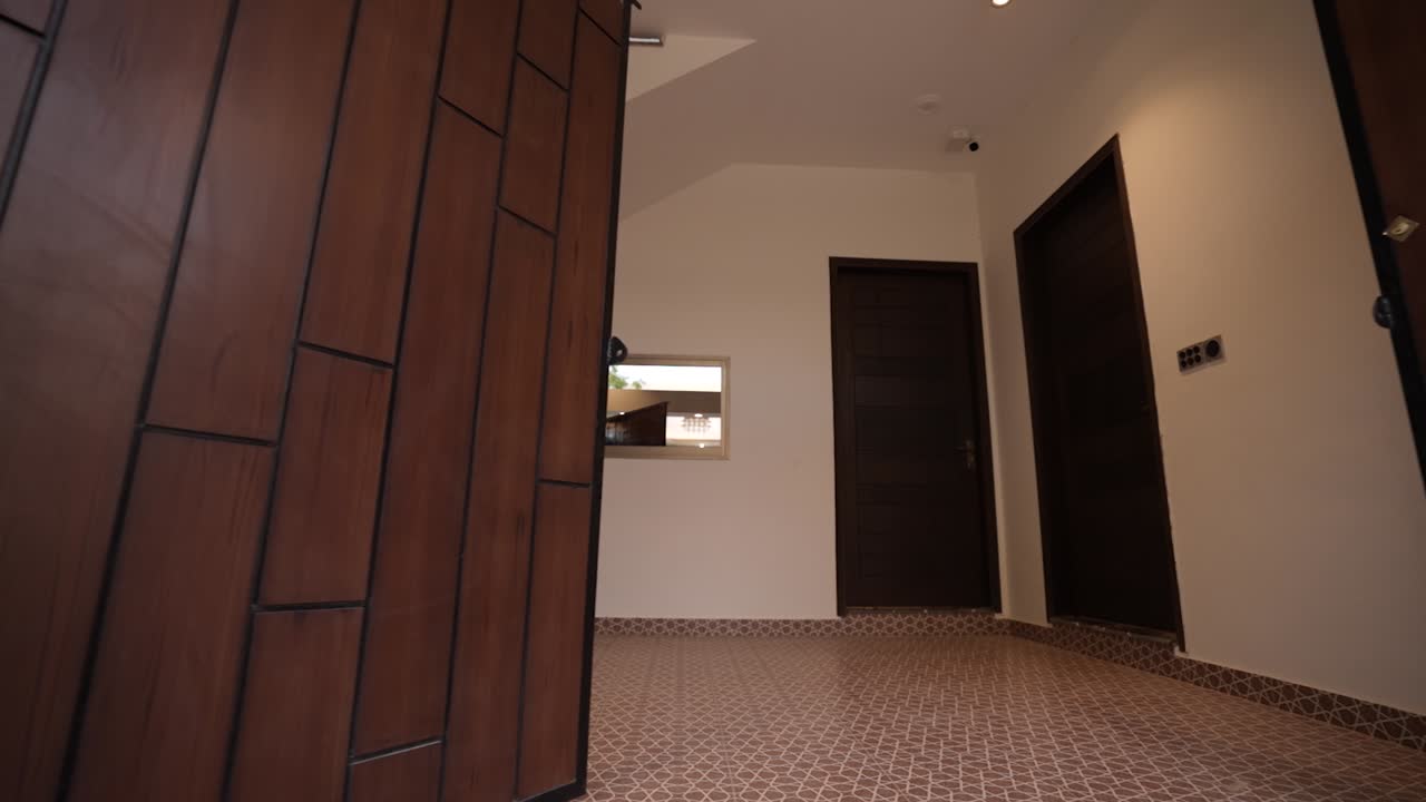 Avvicinamento e passaggio attraverso il portone automatico del garage di una casa in Pakistan.