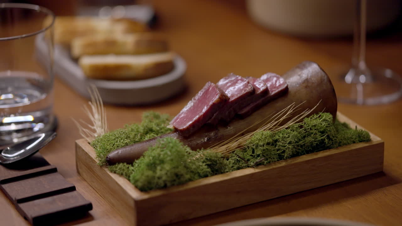 Creative meat dish on a wooden board with moss