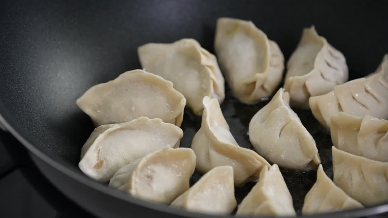 Pan-frying gyoza dumpling jiaozi at home.