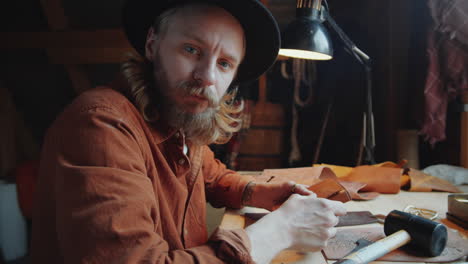 Portrait-of-Leather-Craftsman-at-Desk-in-Workshop