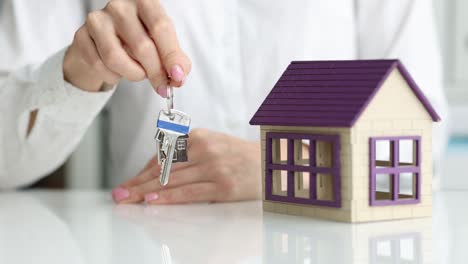 real estate agent holds keys to house and apartment closeup