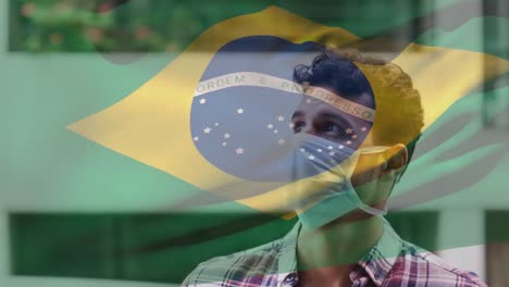 Animation-of-flag-of-brazil-waving-over-laitn-man-wearing-face-mask-in-city-street