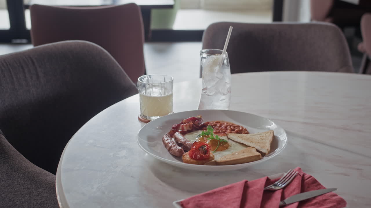 Piatto con cibo per una colazione abbondante e bevanda sul tavolo in un ristorante