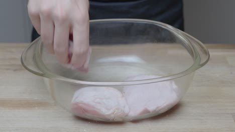 chicken thigs and legs are layered in a glass casserole dish for marinating