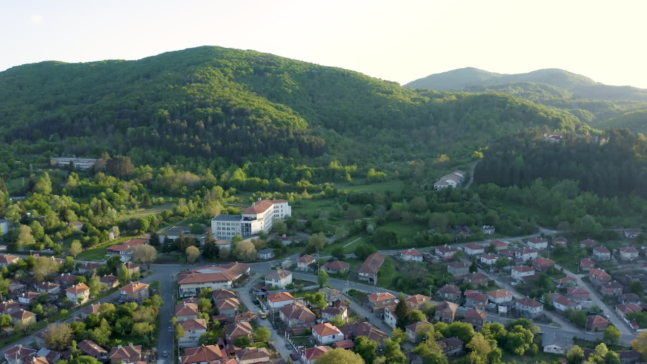 Retreating drone revealing the expanse of a rural community in the municipality of Мalko Tarnovo and the Strandzha Mountain in the background in Bulgaria.