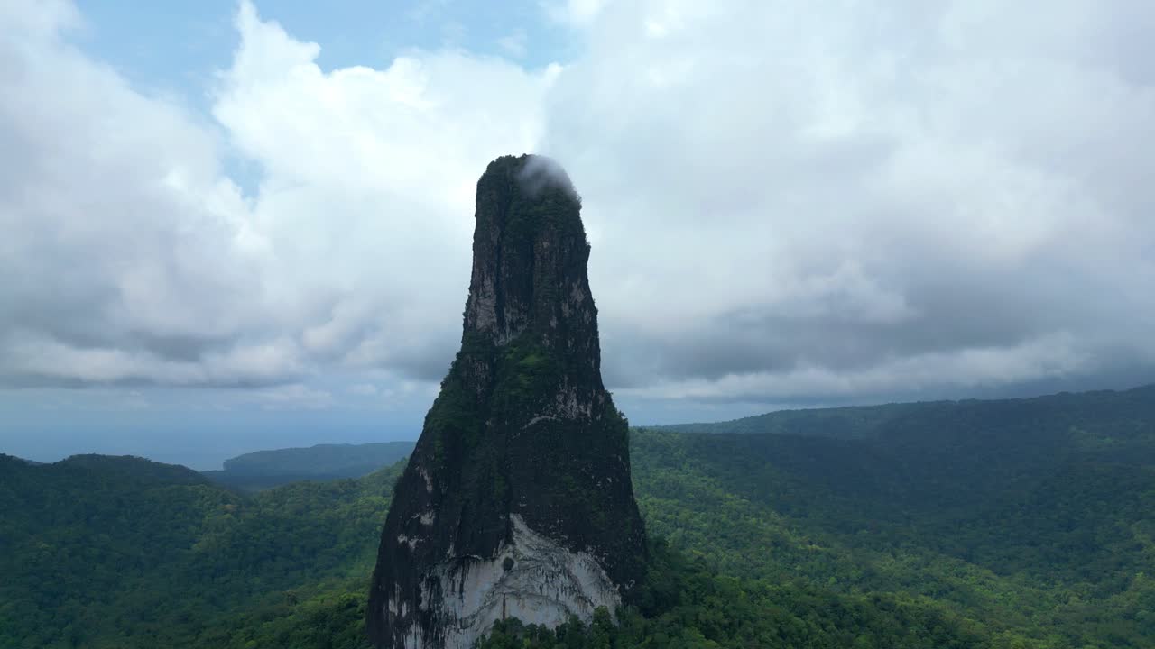 Dairesel bir şekilde uçarak, volkanik kökenli devasa bir monolit olan Peek Cao Grande'ye yakınlaşıyoruz. İğne şeklinde olan bu yapı, São Tomé'nin güneyinde yer alır ve 663 metre yüksekliğindedir.