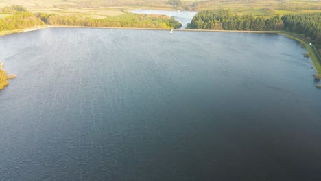 Vista-Aérea-Que-Se-Inclina-Hacia-Arriba-Desde-El-Embalse-Para-Revelar-El-Paisaje-Rural