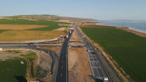 Aerial-drone-shot-over-a-beautiful-two-way-road-network-on-the-seaside-in-Alanya,-Turkey-on-a-sunny-day