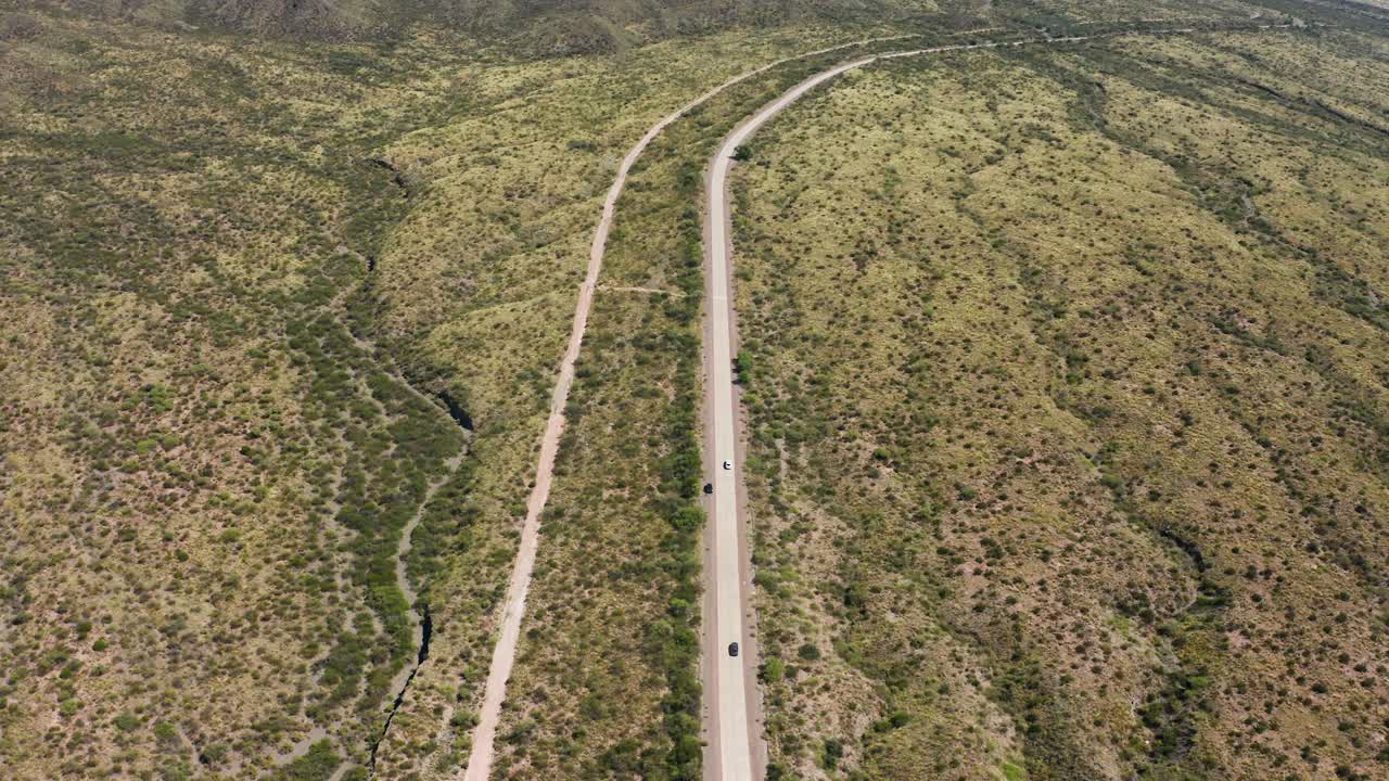 largo camino remoto con autos desde arriba en el árido paisaje desértico, argentina