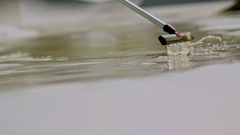 close-up of urban cleaning action with squeegee sliding over wet pavement