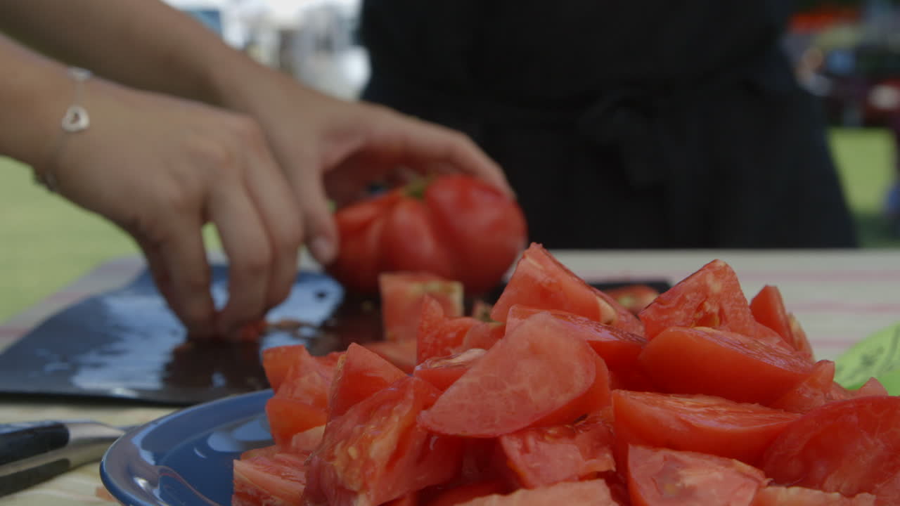 여자 손이 밖에서 테이블 위에 신선한 은 토마토를 잘라
