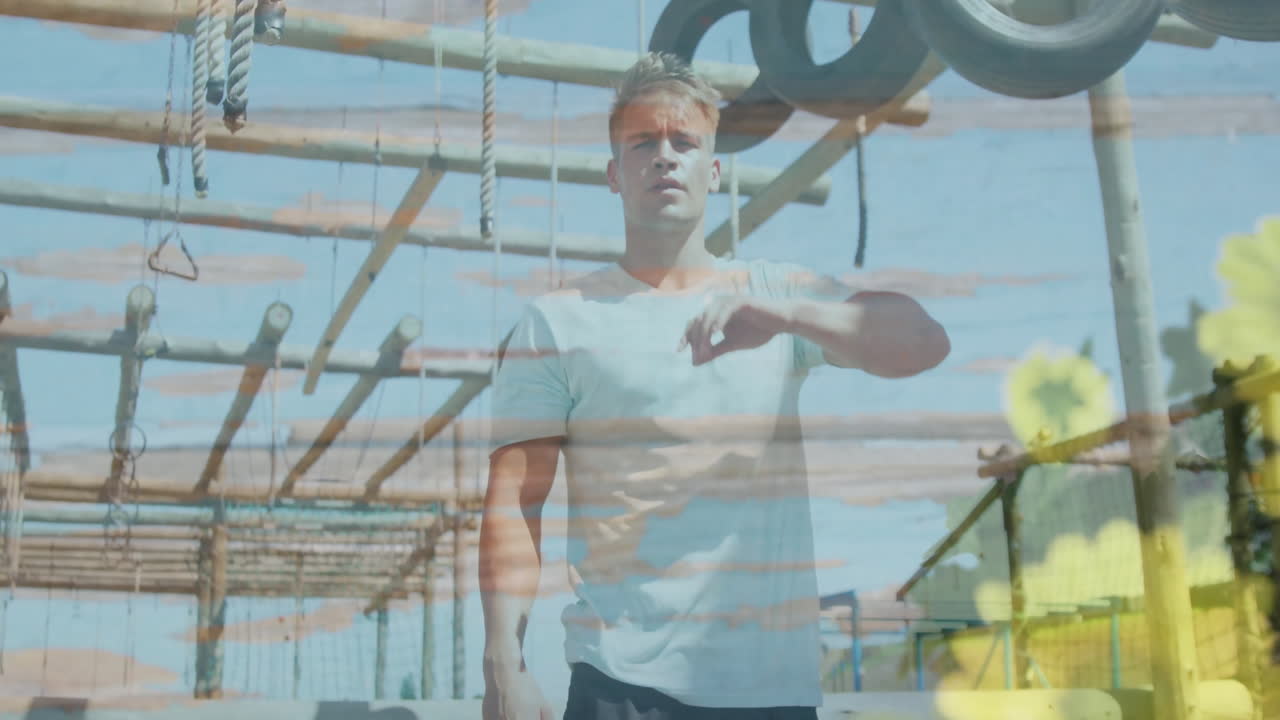 Man wiping forehead over sunflower animation at outdoor obstacle course