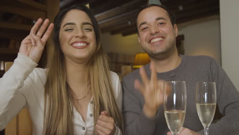 young couple counting down and celebrating turn of the new year during video call