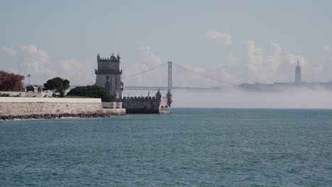 portuguese monument with river in foreground and bridge in background