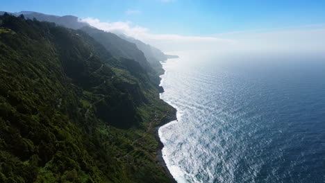 footage at the green slopes of huge rocks at the waterscape of the atlantic ocean. madeira, portugal from aerial view.
