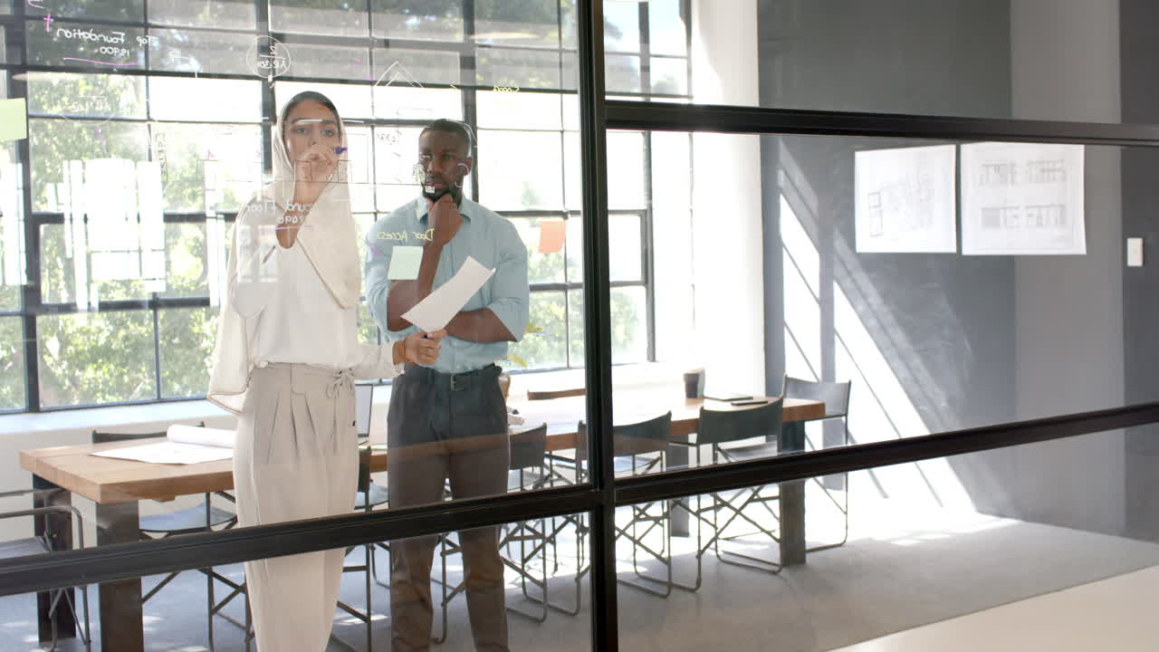 Brainstorming and writing on glass wall, business professionals discussing project in office
