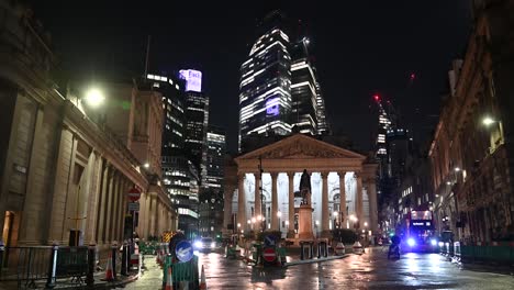 multiple buses driving through the city of london right past the bank of england, london, united kingdom