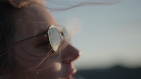 slow motion shot of hair being blown onto a hikers face at the peak of benmore peninsula