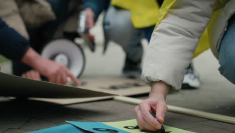 caucasian woman preparing cardboard banners for manifest against ukrainian war.